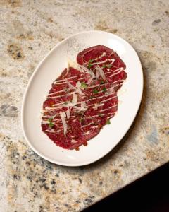 a white plate of food on a table at Boulevard Drobnera SPA&Wellness - Restaurant PONTI - Widok na Odre in Wrocław +153 photos