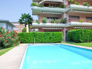 a villa with a swimming pool in front of a building at Apartment Caslago by Interhome in Caslano