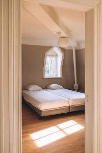 a bedroom with a bed with a window at Portierswoning Vaeshartelt in Maastricht