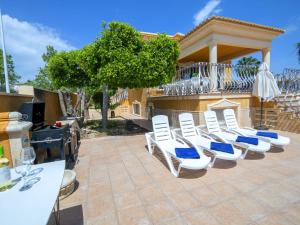 a group of white chairs sitting on a patio at Villa Villa Delfín by Interhome in Calpe