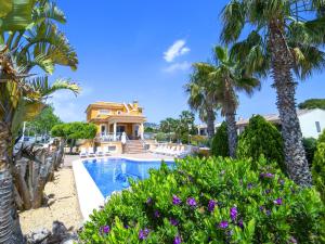 a villa with a swimming pool and palm trees at Villa Villa Delfín by Interhome in Calpe