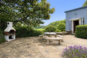 a stone patio with a table and a pizza oven at Le champ godeau in Chilly +3 photos