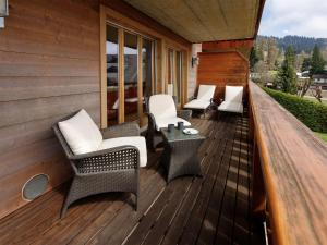a wooden deck with chairs and a table at Apartment Pré Vert 3 by Interhome in Villars-sur-Ollon