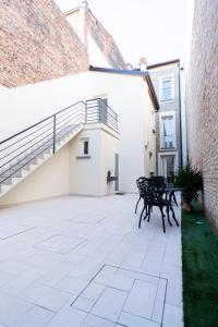 a patio with two benches next to a building at B&B Le Suite del Corso in Lugo