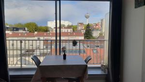 a table and chairs in a room with a large window at LePré Apartment 93 in Le Pré-Saint-Gervais