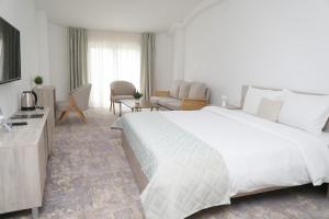 a bedroom with a large white bed and a living room at Coconut Hotel And Pool in Gevgelija +52 photos