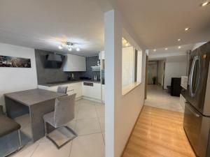 a kitchen and living room with a table and refrigerator at Seafront Apartment Bakar in Bakar