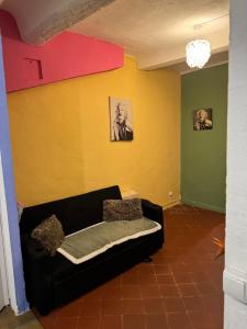a black couch in a room with a yellow wall at Demane-bebbih in Étouars