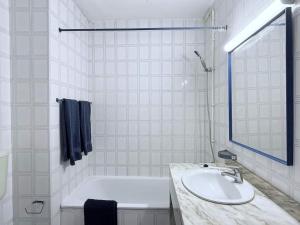 a white bathroom with a tub and a sink at Sunny Beach Praia da Rocha Sea Views Algarve in Portimão