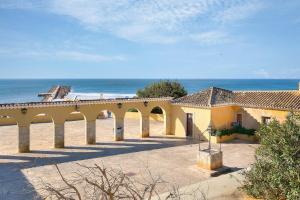 a building on the beach with the ocean in the background at Sunny Beach Praia da Rocha Sea Views Algarve in Portimão