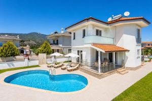 a villa with a swimming pool in front of a house at Villa Veli in Dalyan
