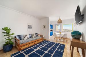 a living room with a bed and a table at Sunny Beach Praia da Rocha Sea Views Algarve in Portimão +25 photos