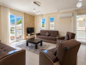a living room with a couch and chairs and a tv at Villa Veli in Dalyan
