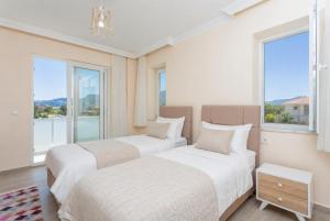 two beds in a room with large windows at Villa Veli in Dalyan +20 photos