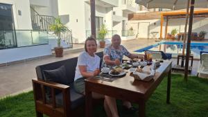 a man and a woman sitting at a table with food at Malak house swimming pool &Garden in Luxor