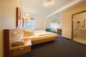 a hotel room with a bed and a bathroom at Montana Hotel in Oberasbach