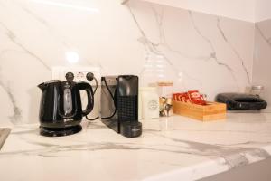 a black coffee maker sitting on a kitchen counter at Golden View Suites with hot tub in Vóthon