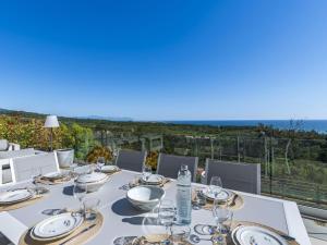 a table with glasses and plates on top of a balcony at Villa Casa Minà by Interhome in Sari Solenzara