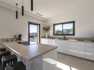 a kitchen with white cabinets and a large island at Villa Casa Minà by Interhome in Sari Solenzara
