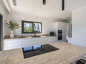 a kitchen with white cabinets and a sink and a mirror at Villa Casa Minà by Interhome in Sari Solenzara