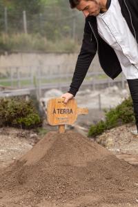 a man is putting a sign on a mound of dirt at Octant Furnas in Furnas