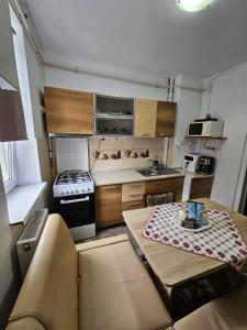 eine kleine Küche mit einem Tisch und einem Herd in der Unterkunft D'oro in Tulcea