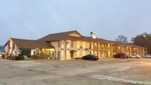 a large building with cars parked in a parking lot at TexInn Motel New Boston in New Boston