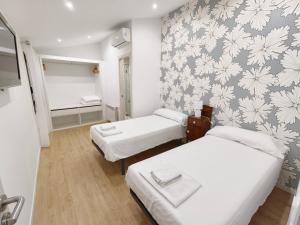 a room with two beds and a wall with flowers at Ca Na Margalida in Muro +27 photos