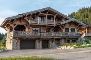 a large wooden house with a balcony at Chalet de l'Atray in Les Gets