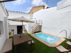 a backyard with a swimming pool and a table and an umbrella at Ca Na Margalida in Muro