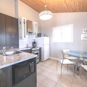 a kitchen with a sink and a table with chairs at Lantern Hill & Hollow in Ingonish Beach