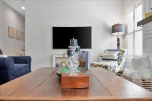 a living room with a wooden table and a tv at Rivercrest Bungalow Retreat in Tampa