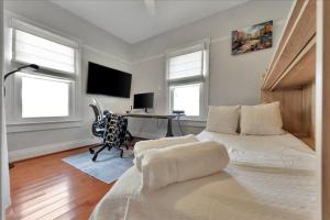 a bedroom with a bed and a desk with a computer at Rivercrest Bungalow Retreat in Tampa