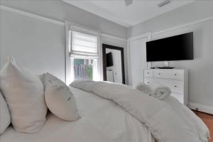 a white bed with pillows on it in a room at Rivercrest Bungalow Retreat in Tampa
