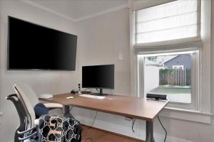 a home office with a desk and a tv at Rivercrest Bungalow Retreat in Tampa