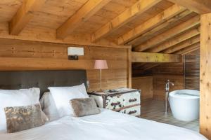 a bedroom with a bed and a bath tub at Chalet de l'Atray in Les Gets