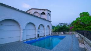 a house with a swimming pool next to a building at Aijal Club in Āīzawl