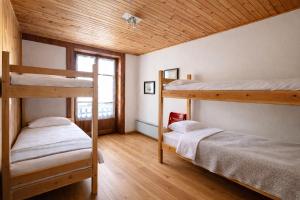 two bunk beds in a room with wooden ceilings at Appartamento Alta Valle Maira - Nebin in Villaro