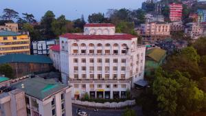 a large white building with a red roof in a city at Aijal Club in Āīzawl