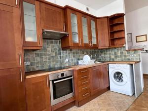 a kitchen with wooden cabinets and a washer and dryer at Wrocławska Rooms in Poznań