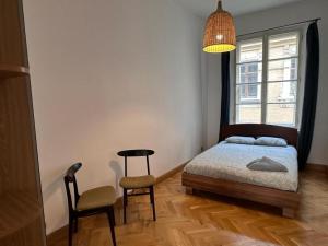 a bedroom with a bed and a chair and a window at Wrocławska Rooms in Poznań