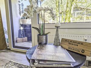 a table with books and a vase with flowers on it at Apartment Grubhof by Interhome in Scheffsnoth +52 photos
