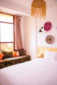 a bedroom with a bed and a window and a couch at Salty Life Surf House in Imsouane