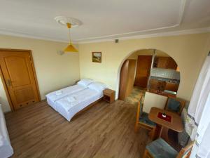a bedroom with a bed and a room with a table at Domek Przy Potoku in Biały Dunajec