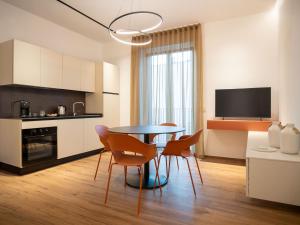a kitchen and dining room with a table and chairs at BOREMA Apulian Rooms in Andria