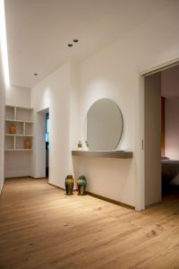 a living room with a mirror and a wooden floor at BOREMA Apulian Rooms in Andria