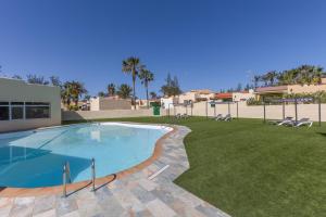 a swimming pool in a yard with chairs and a lawn at Casita Darmelo in Costa Calma