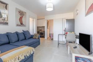 a living room with a blue couch and a table at Casita Darmelo in Costa Calma