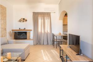 a living room with a couch and a tv at Spiros house in Svoronata