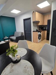 a living room with a table and chairs and a kitchen at Apartamenty Nad Suwalskim Bulwarem in Suwałki +11 photos
